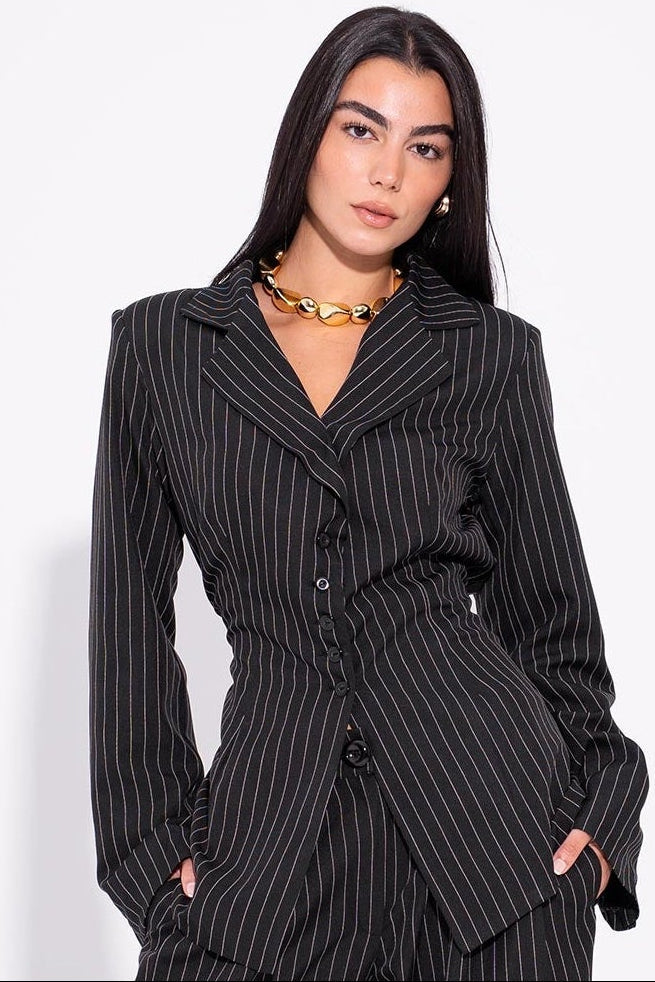 Woman wearing a black pinstripe suit on a white background