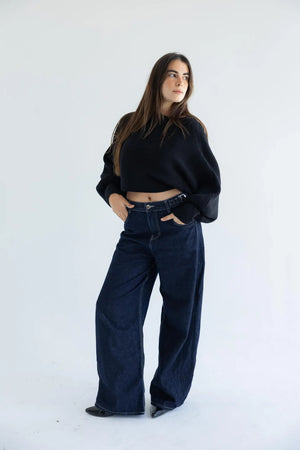 Black off-shoulder pullover with dark wide-leg jeans - full length